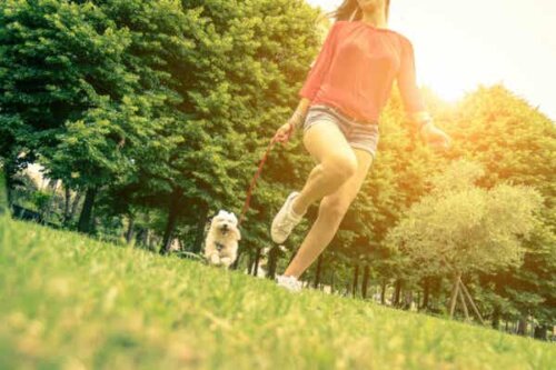 En kvinne som løper med en hund.