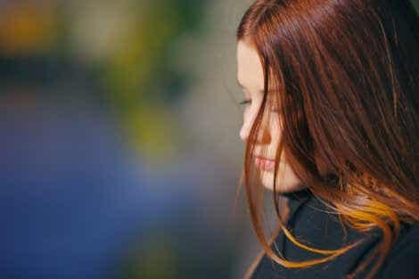 En bekymret kvinne som ser ned.