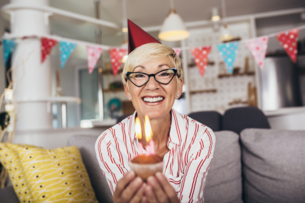Senior kvinne med en bursdagskake som viser oppveksten